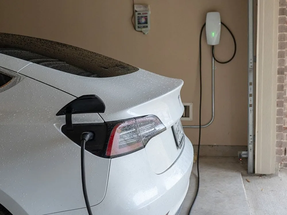 Tesla connected to a home EV charger in a garage