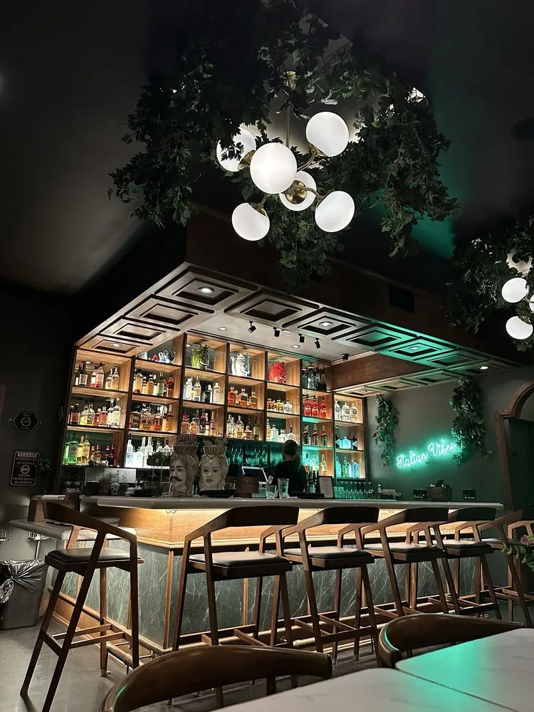 Trenta Lounge at Trenta Pizza & Cucina in Costa Mesa, California, with globe chandeliers and illuminated bar shelving